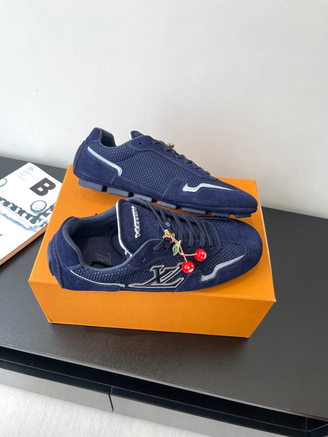 Louis Vuitton ladies navy sneakers, angled top view with lace-up and charm embroidery