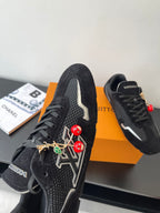 Black Louis Vuitton sneakers, side view with white logo stripe and charms