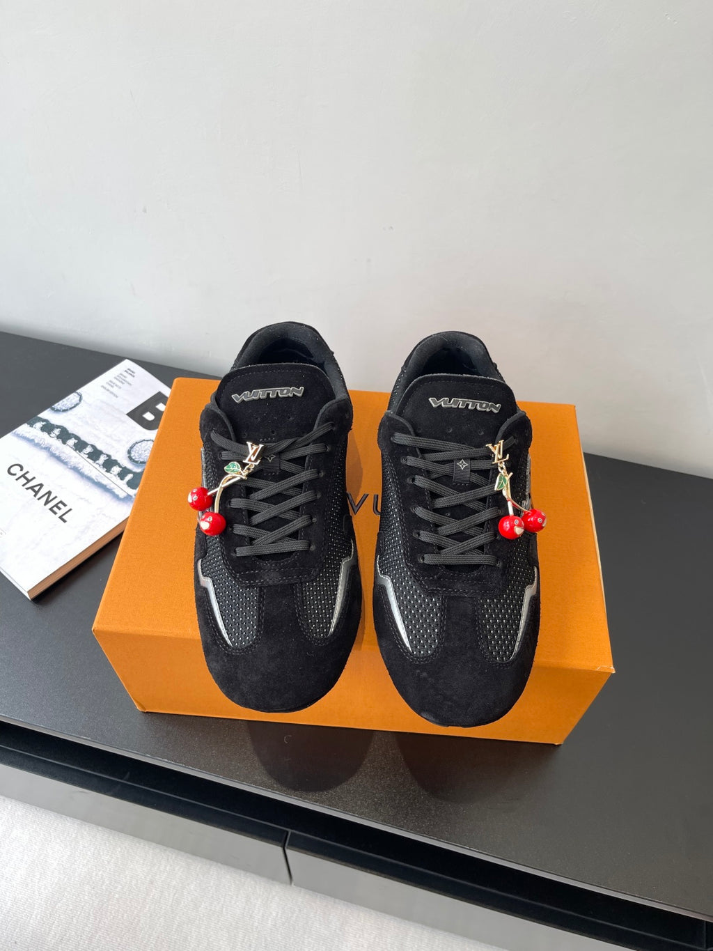 Black Louis Vuitton sneakers with lace-up front and red charm detail