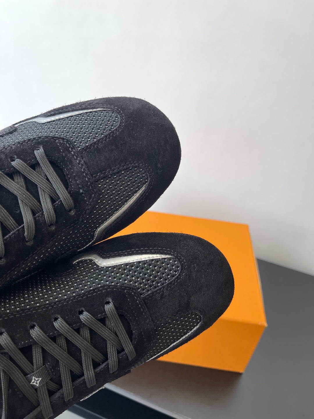 Black Louis Vuitton sneakers, close-up of textured side panel and laces