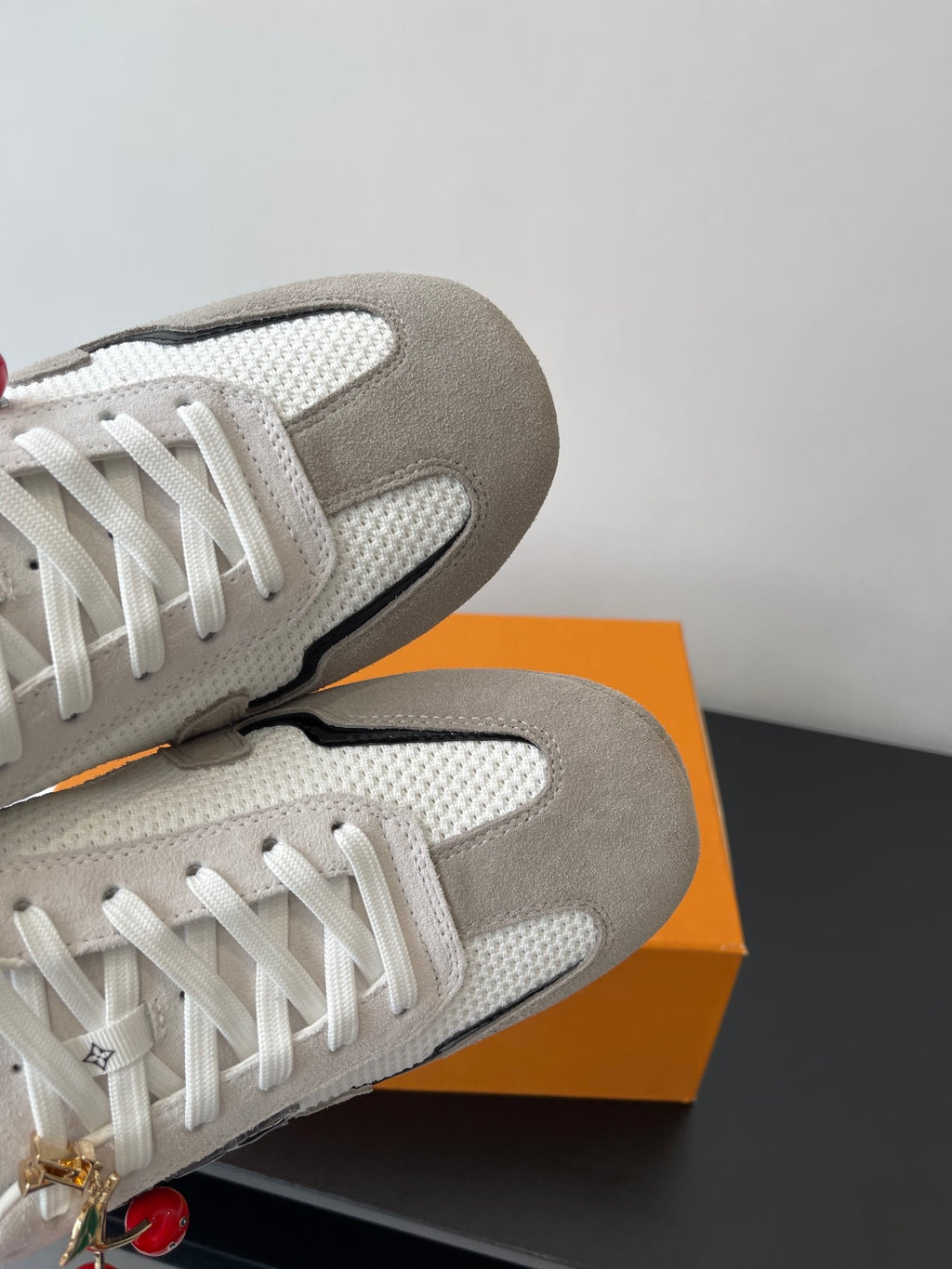 Louis Vuitton sneakers close-up, off-white uppers with white laces and gray toe cap