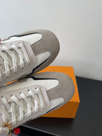 Louis Vuitton sneakers close-up, off-white uppers with white laces and gray toe cap