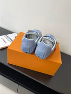 Light-blue sneakers heel view with cushioned collar and lace-up design on an orange box