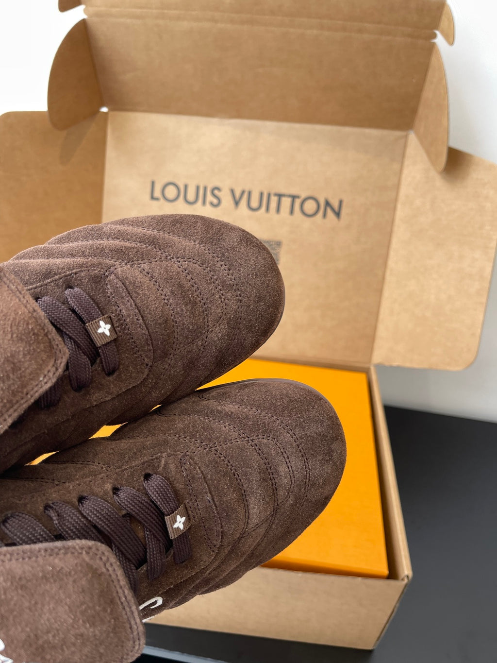 Brown suede sneakers close-up, lace-up with small star emblem