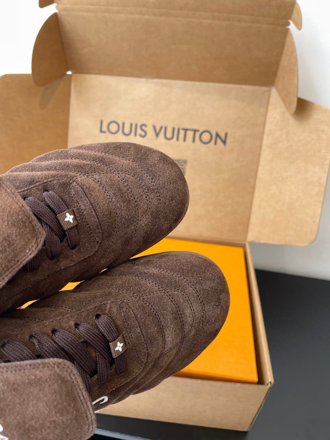 Brown suede sneakers close-up, lace-up with small star emblem
