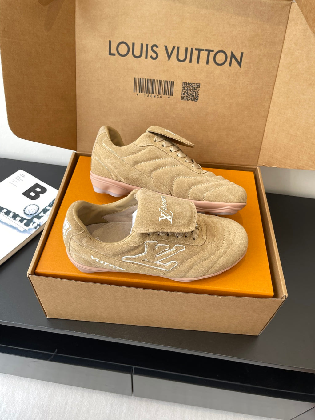 Beige Louis Vuitton women’s sneakers in box, angled pair with lace-up tops