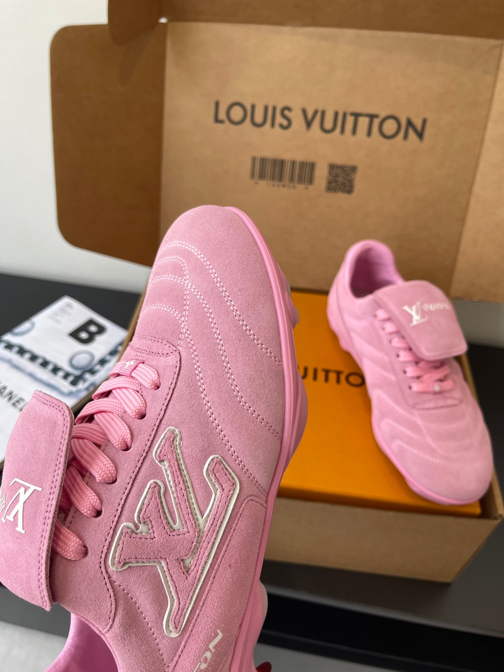 Louis Vuitton women's pink sneakers, side profile with stitched logo outline