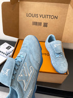 Light blue lace-up sneakers with Louis Vuitton logo, side view in open box