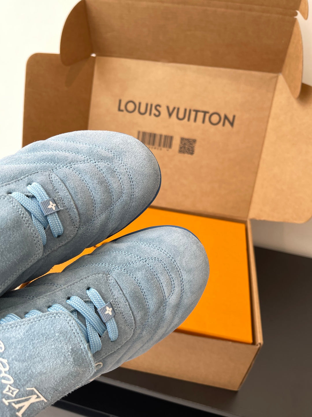 Light blue sneakers with laces, close-up of uppers in open box