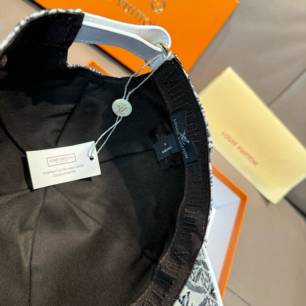 Baseball cap interior with black lining, Louis Vuitton-style logo badge and hanging tags.