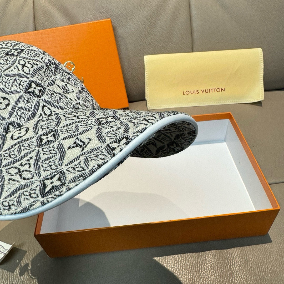 Monogram-pattern baseball cap brim and side panel in dark gray/black, close view.