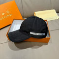 Louis Vuitton dark baseball cap with curved brim and front logo band.