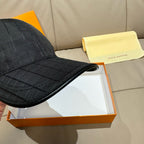 Louis Vuitton dark baseball cap with curved brim and textured check fabric.