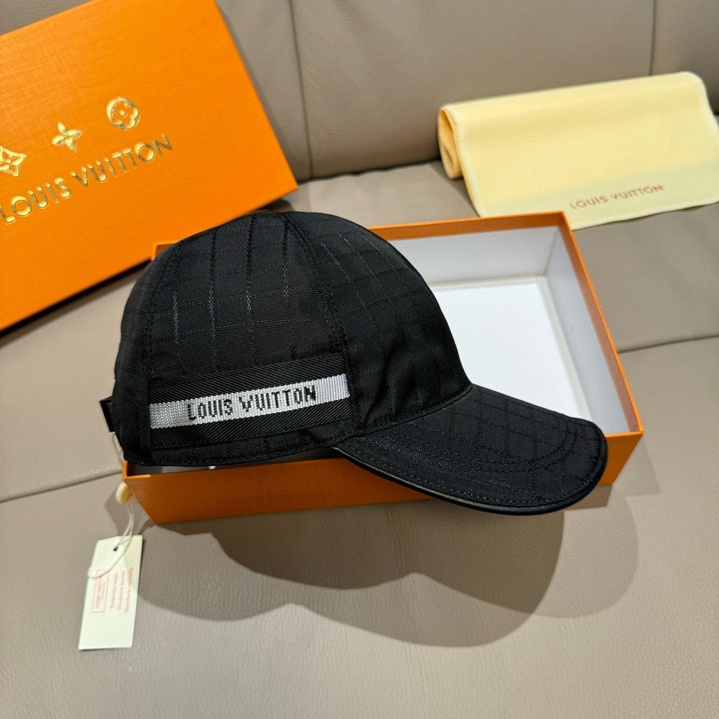 Louis Vuitton dark baseball cap with front logo band and hanging tag on brim.