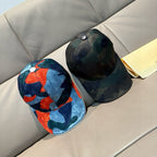 Two baseball caps side by side: dark green and dark blue orange logo prints
