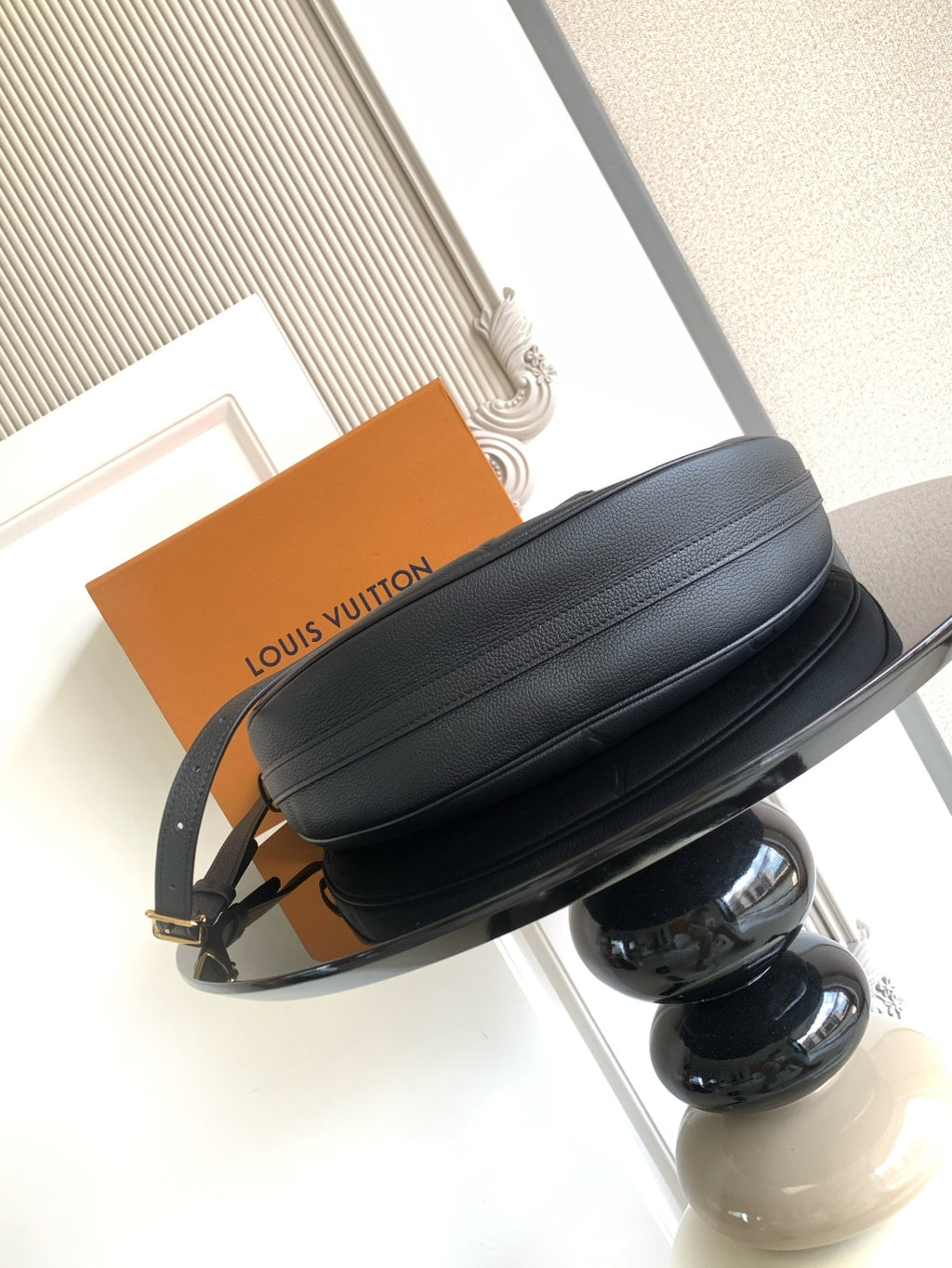 Louis Vuitton crossbody bag in dark leather with top zipper and gold hardware