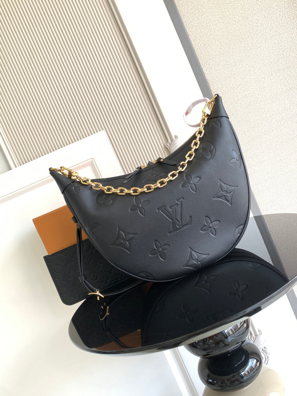 Louis Vuitton hobo bag in dark leather with embossed monogram and gold chain strap