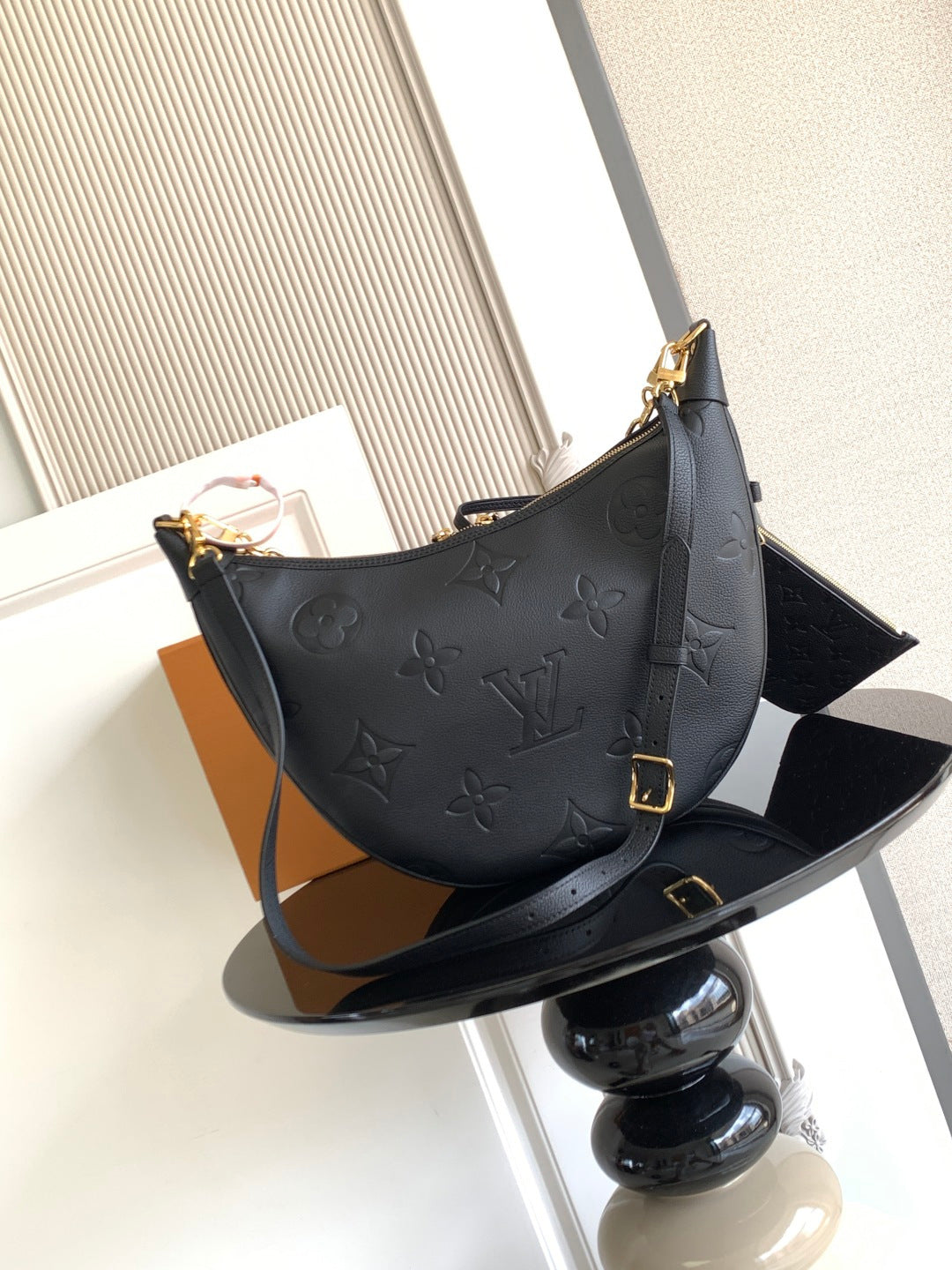 Louis Vuitton hobo bag in dark leather with embossed monogram and gold buckle strap