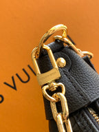 Louis Vuitton bag close-up with gold padlock clasp and chain on dark leather