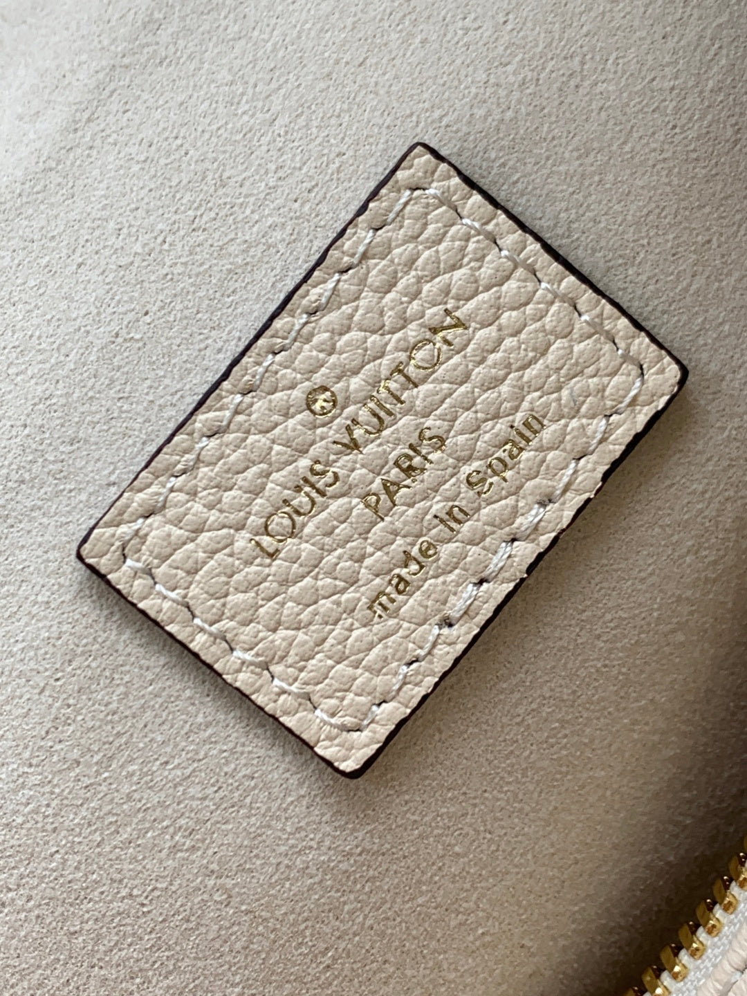 Louis Vuitton card holder in light beige textured leather with embossed logo on front
