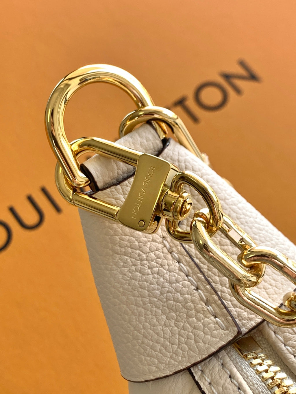 Louis Vuitton keychain charm with light beige leather strap and gold metal clasp