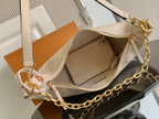 Louis Vuitton handbag with top zipper open, light beige interior and gold chain strap