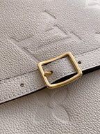 Louis Vuitton leather strap with gold-tone buckle on light beige pebble-grain material