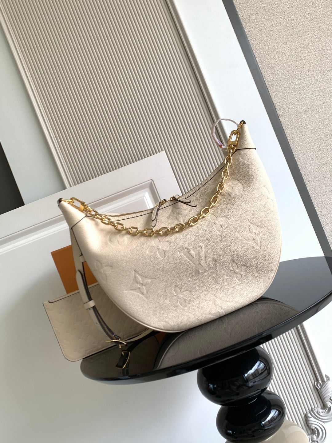 Louis Vuitton hobo bag in light beige with embossed monogram and gold chain strap