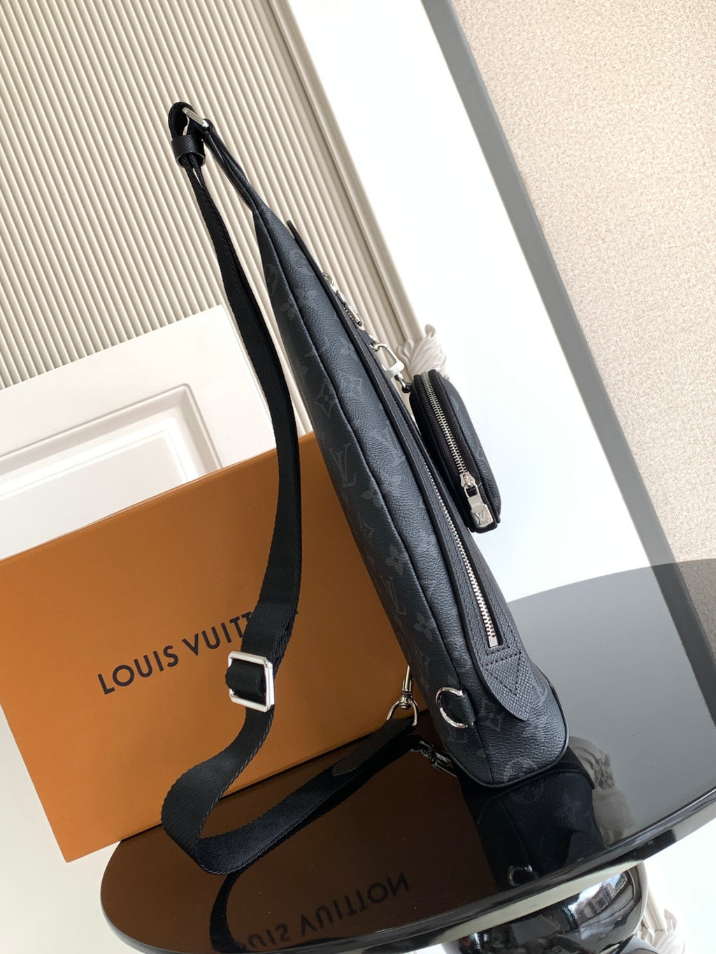 Louis Vuitton monogram crossbody bag side view with zipper pull and shoulder strap