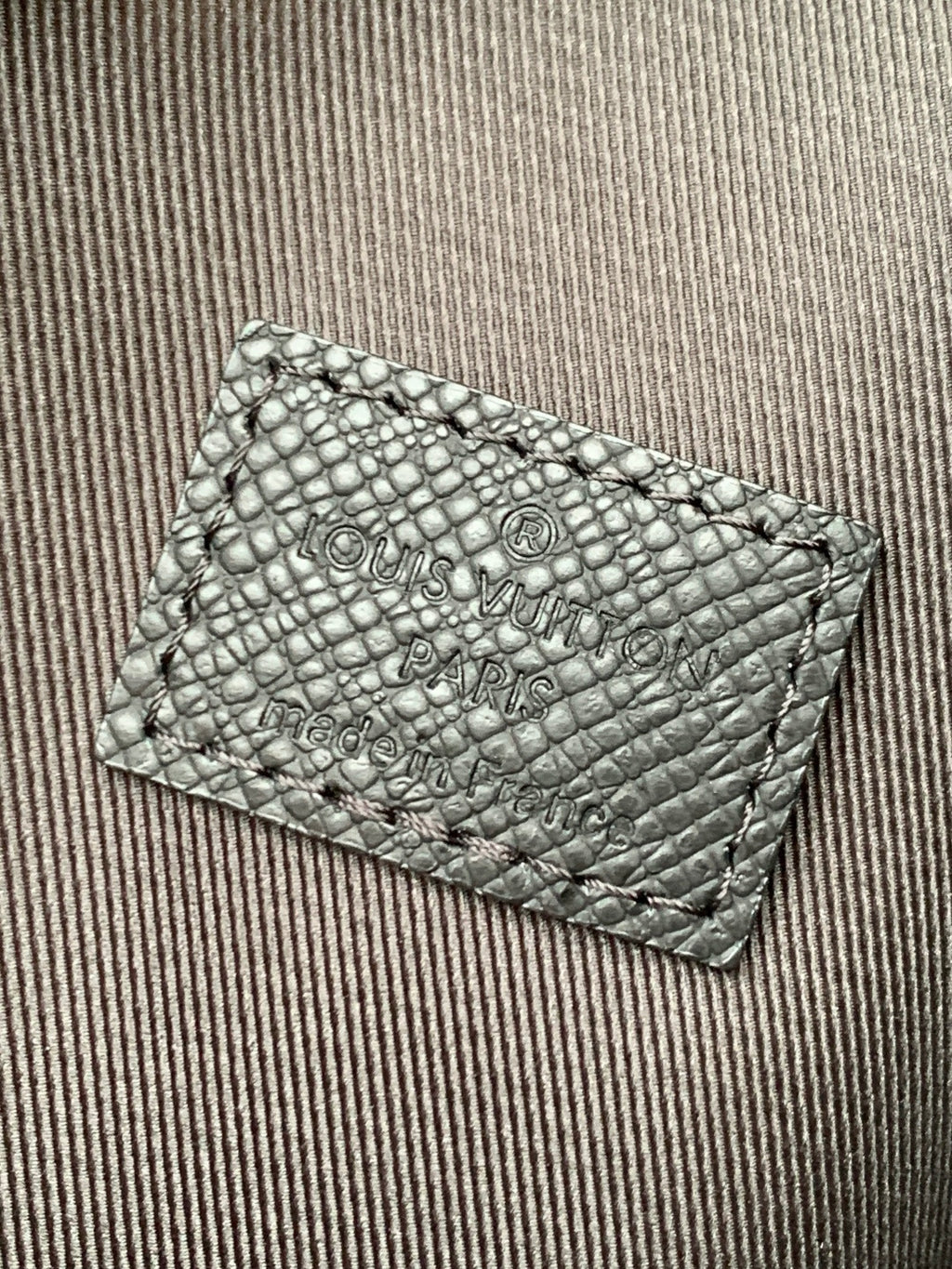 Louis Vuitton embossed leather card holder with logo text