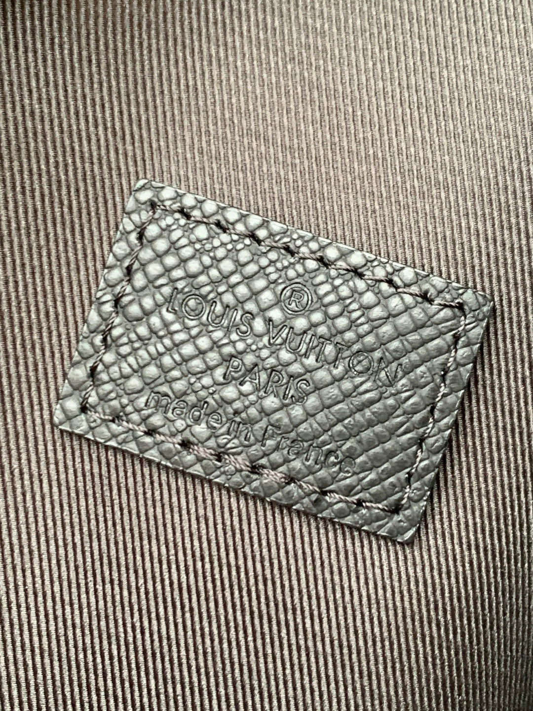 Louis Vuitton embossed leather card holder with logo text