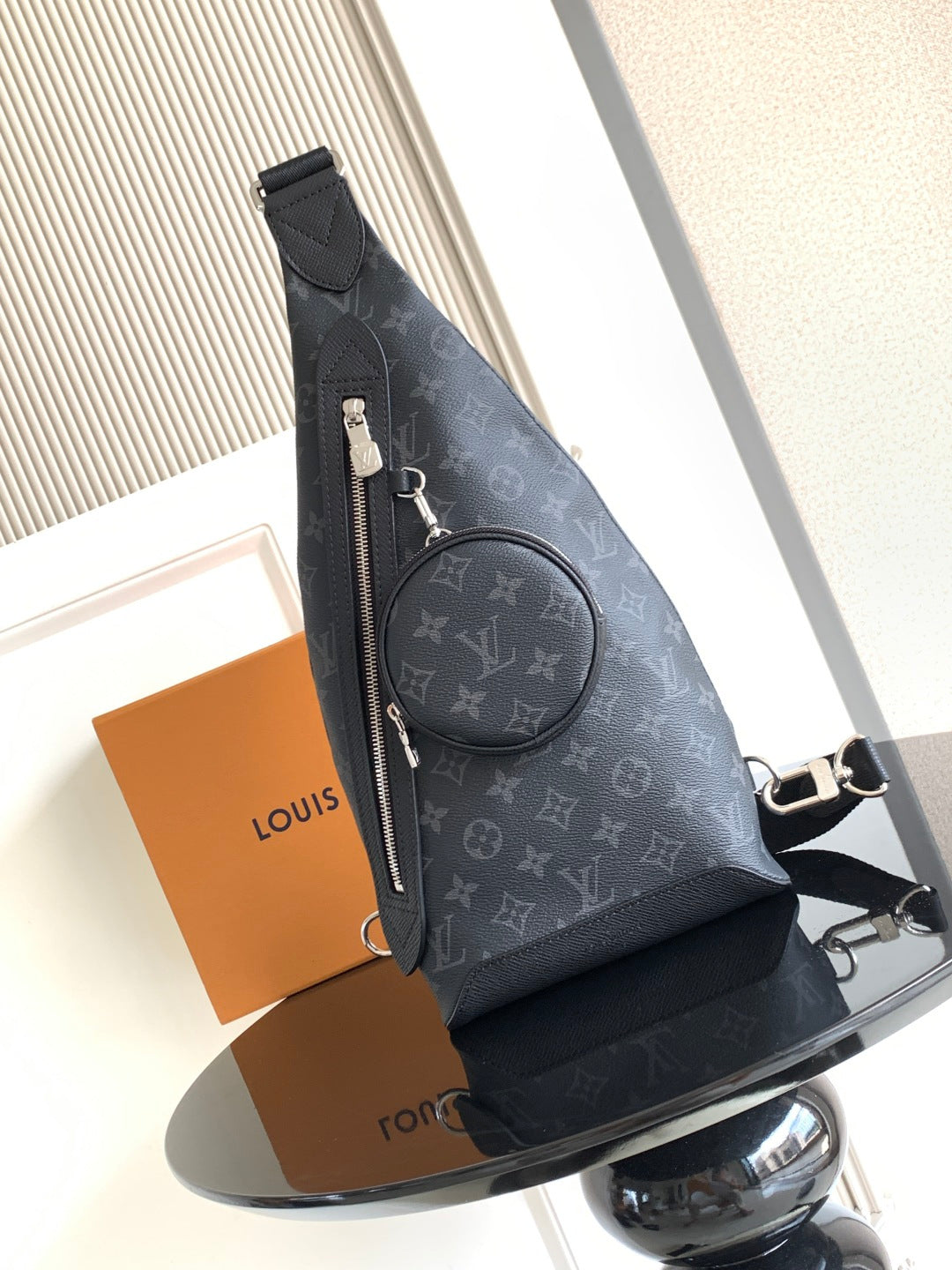 Louis Vuitton monogram crossbody bag with front zipper and round logo badge