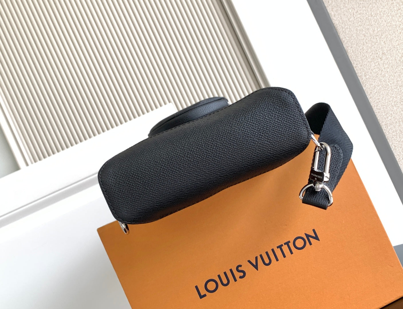 Louis Vuitton textured leather crossbody bag end with metal zipper pull