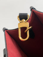 Louis Vuitton bag interior close-up with red lining and gold clasp hardware