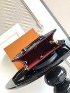 Louis Vuitton bag open interior with red lining, gold hardware, and black exterior