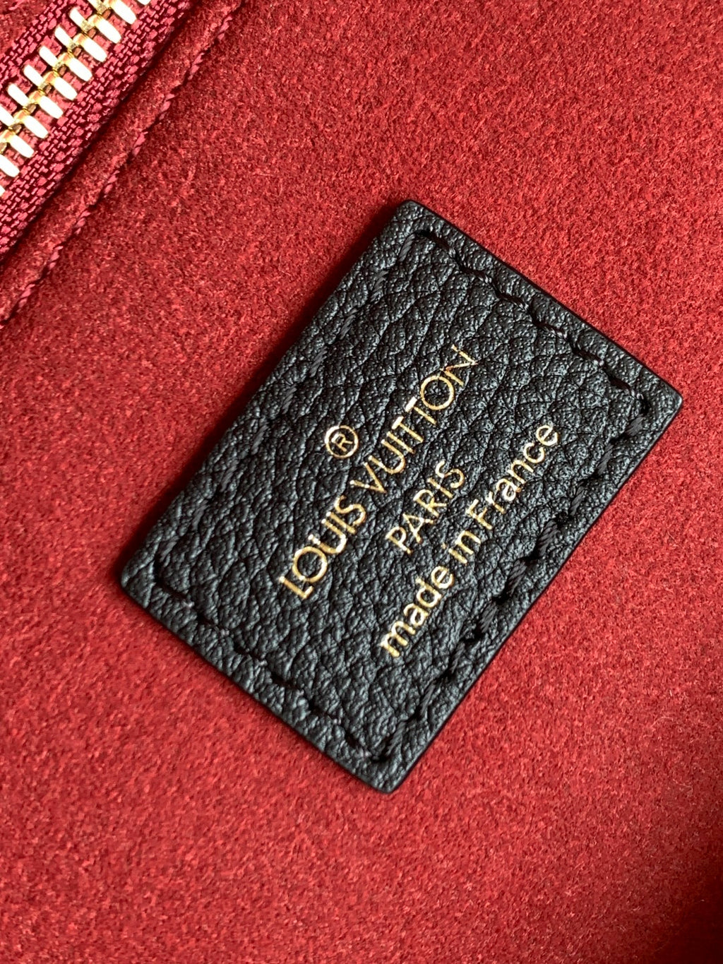 Louis Vuitton made-in France leather tag on red fabric lining with gold lettering