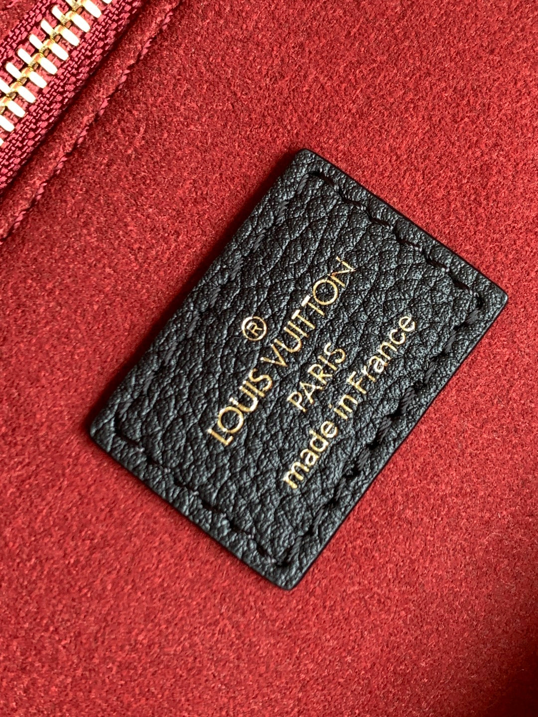 Louis Vuitton made-in France leather tag on red fabric lining with gold lettering