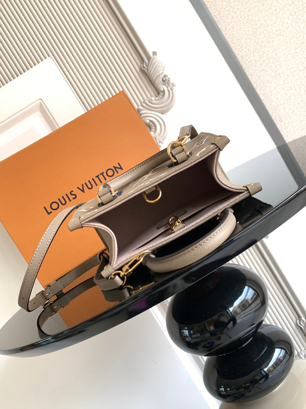 Louis Vuitton monogram handbag with open top view and taupe crossbody strap