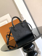 Louis Vuitton black embossed leather tote bag with top handles and crossbody strap