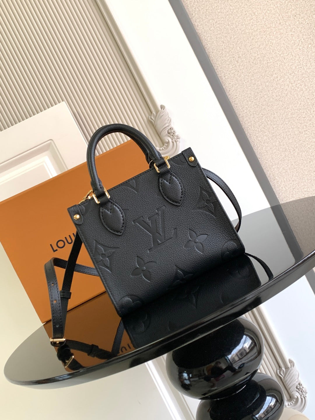Louis Vuitton black embossed leather tote bag with top handles and crossbody strap