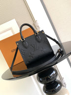 Black embossed leather tote bag with top handles and long strap