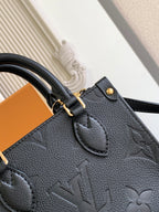 Black embossed leather tote bag front with stitched pocket and gold clasp