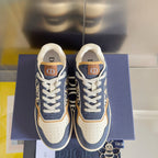Pair of unisex blue denim sneakers with white laces, tan trim, and logo tongue patch