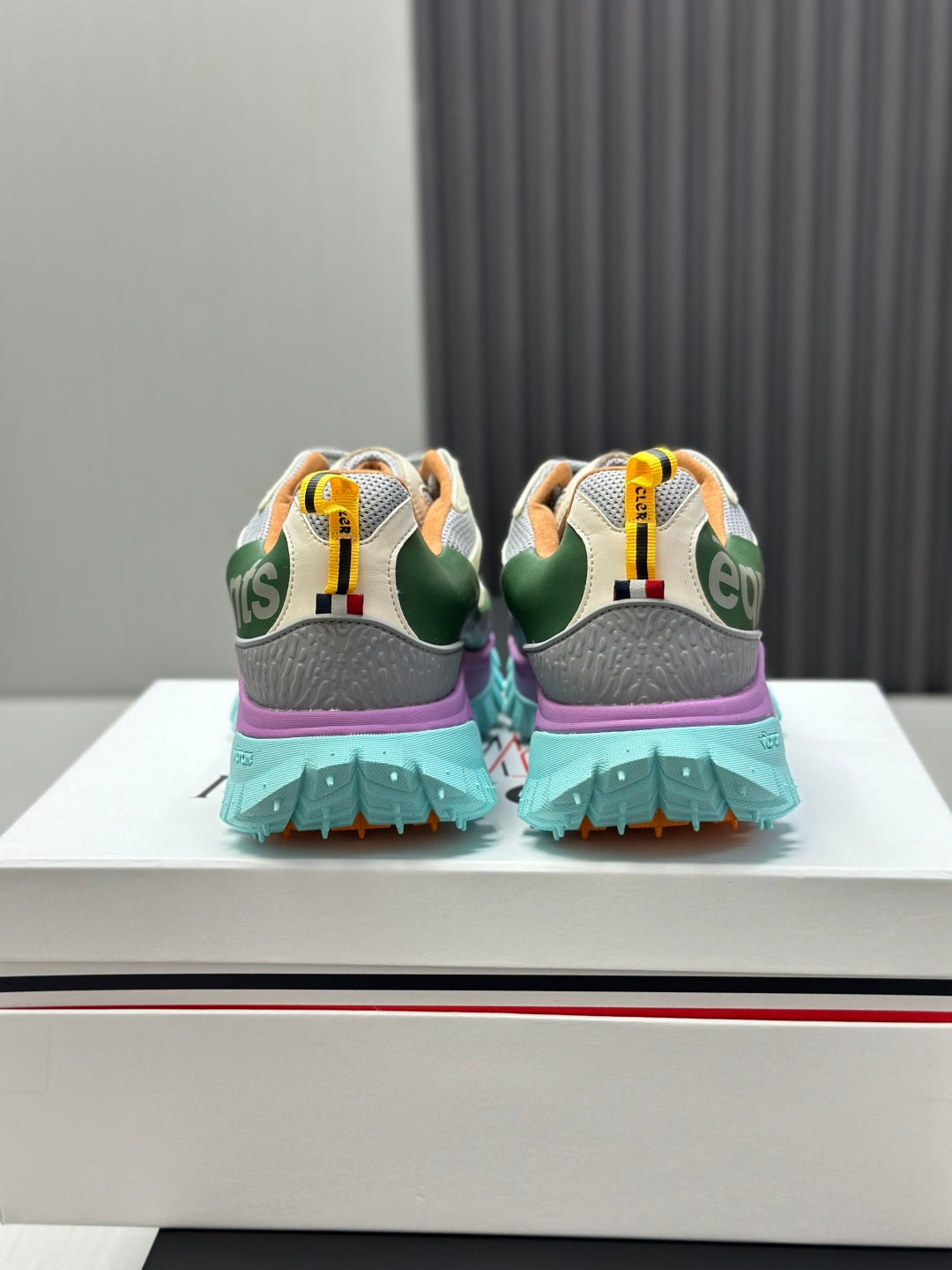 Back view of two-tone sneakers with mint tread sole and purple heel accents.