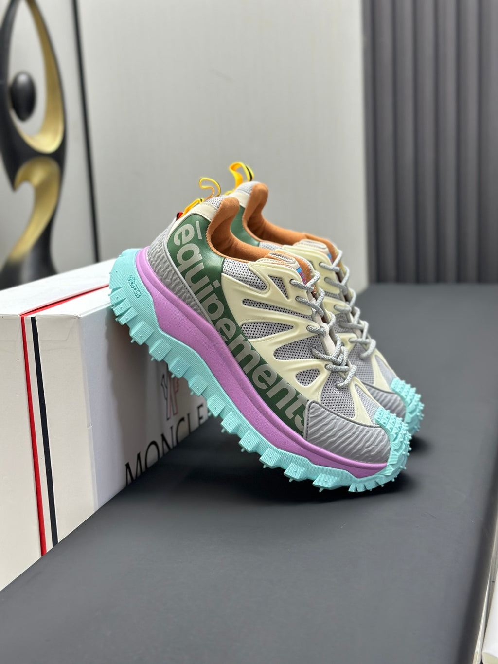 Grey lace-up sneakers with purple side panel and turquoise tread sole.