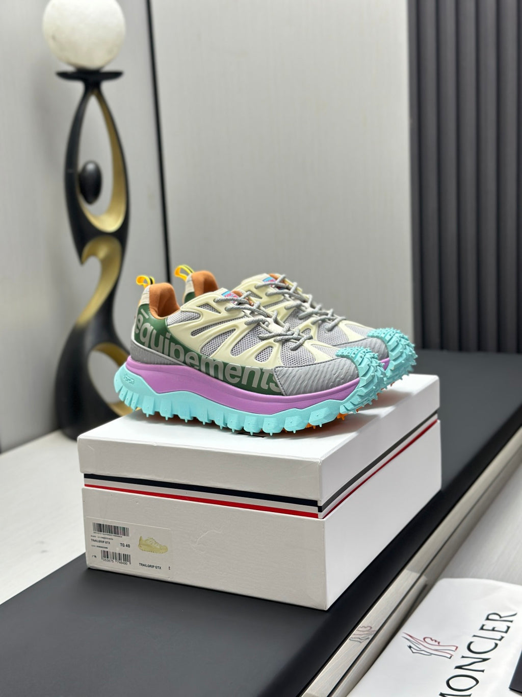 Light grey lace-up sneakers with purple panel and turquoise tread sole.
