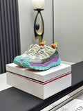 Grey trail sneakers with mint rubber sole and purple side stripe, lace-up.