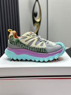 Grey lace-up sneakers with turquoise tread sole and purple side stripe, side view.