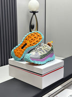 Grey lace-up sneakers with mint outsole tread and orange-speckled underside.