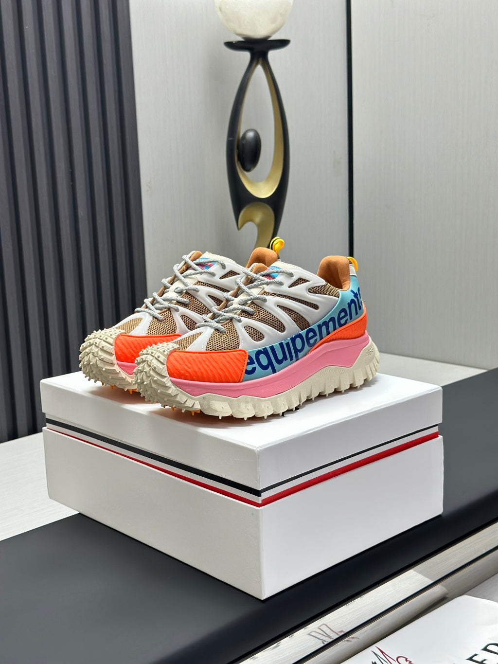 Moncler trail sneaker with white laces, orange and pink side panels, blue heel detail